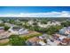 An aerial view showcasing the neighborhood's cozy homes and lush green landscape under a bright, partly cloudy sky at 9201 Spy Glass Ct, Tampa, FL 33615