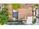 An aerial view displaying a property with its unique roof design and backyard layout with car and landscaping at 9201 Spy Glass Ct, Tampa, FL 33615