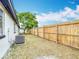 Fenced backyard showcasing well-maintained lawn, mature trees, and side of house at 9201 Spy Glass Ct, Tampa, FL 33615