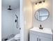 Updated bathroom with a new vanity, round mirror, and walk-in tiled shower with modern fixtures at 9201 Spy Glass Ct, Tampa, FL 33615