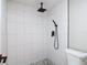 Tiled walk-in shower features modern black fixtures and a river rock shower floor at 9201 Spy Glass Ct, Tampa, FL 33615