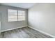 Cozy bedroom with wood-look floors and natural light from a window at 9201 Spy Glass Ct, Tampa, FL 33615