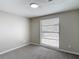 This bedroom features neutral walls, carpet, window, and a modern ceiling light at 9201 Spy Glass Ct, Tampa, FL 33615