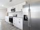 Modern kitchen with stainless steel appliances, white cabinets, and quartz countertops at 9201 Spy Glass Ct, Tampa, FL 33615
