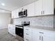 Updated kitchen featuring white cabinets, quartz countertops, and stainless steel appliances at 9201 Spy Glass Ct, Tampa, FL 33615