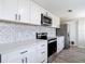 Modern kitchen with sleek white cabinets, updated appliances, and stylish backsplash at 9201 Spy Glass Ct, Tampa, FL 33615