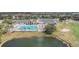 Aerial view of clubhouse, pool, golf course, and surrounding pond, showcasing community amenities at 9723 Rolling Cir, San Antonio, FL 33576