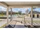 View from the porch to a community pool area with lounge chairs and shade umbrellas at 9723 Rolling Cir, San Antonio, FL 33576