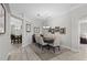 Formal dining area with a wooden table set for six, complemented by decorative wall art and luxury vinyl plank flooring at 9723 Rolling Cir, San Antonio, FL 33576
