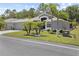 Charming single-story home featuring a well-manicured lawn, mature trees, and a two-car garage at 9723 Rolling Cir, San Antonio, FL 33576