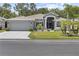 Charming single-story home featuring a well-manicured lawn, mature trees, and a two-car garage at 9723 Rolling Cir, San Antonio, FL 33576