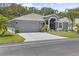 Charming single-story home featuring a well-maintained lawn and a two-car garage at 9723 Rolling Cir, San Antonio, FL 33576