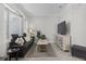 Cozy living room featuring a plush sofa, large windows, and a modern entertainment center at 9723 Rolling Cir, San Antonio, FL 33576