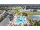 Aerial view of a large community pool with a clubhouse, golf course, and lake at 9723 Rolling Cir, San Antonio, FL 33576