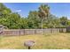 Grassy fenced backyard featuring lush trees for outdoor enjoyment at 10016 Glen Moor Ln, Port Richey, FL 34668