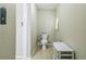 Bright half-bathroom with tiled floors, toilet, and storage cabinet at 10016 Glen Moor Ln, Port Richey, FL 34668