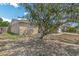 A view of the single Gathering home from the side, featuring a large tree and lush grass at 10016 Glen Moor Ln, Port Richey, FL 34668