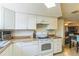 Well-lit kitchen with white cabinets, modern appliances, and tiled floors at 10016 Glen Moor Ln, Port Richey, FL 34668