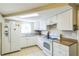 Bright kitchen features white cabinets and appliances at 10016 Glen Moor Ln, Port Richey, FL 34668