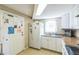 Bright kitchen features white cabinets and appliances and access to the backyard at 10016 Glen Moor Ln, Port Richey, FL 34668