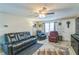 Cozy living room boasts a comfortable reclining sofa and ample natural light at 10016 Glen Moor Ln, Port Richey, FL 34668