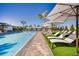 Community pool with blue water, lounge chairs, white umbrellas and blue skies at 10217 Purple Leaf Ct, Riverview, FL 33578
