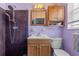 Compact bathroom featuring a shower, wood vanity, and updated fixtures for a functional space at 10448 Hetrick W Cir, Largo, FL 33774