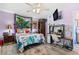Bright bedroom featuring a floral-patterned quilt, vanity area, and mounted television for comfortable living at 10448 Hetrick W Cir, Largo, FL 33774