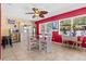 Bright dining room featuring tile floors and a modern glass-top table, illuminated by a unique ceiling fan at 10448 Hetrick W Cir, Largo, FL 33774