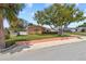 Charming, single-story home features a well-manicured lawn, mature trees, and a peach-colored exterior at 10448 Hetrick W Cir, Largo, FL 33774