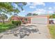 Charming single-story home featuring a manicured lawn and a spacious two-car garage at 10448 Hetrick W Cir, Largo, FL 33774