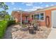 A charming front patio area with brick pavers, potted plants, and a cozy seating area at 10448 Hetrick W Cir, Largo, FL 33774