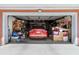 View of the home's two-car garage showing ample storage space and a red car parked inside at 10448 Hetrick W Cir, Largo, FL 33774