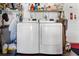 The home's laundry area includes a new washer and dryer with overhead shelving for storage at 10448 Hetrick W Cir, Largo, FL 33774