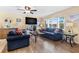 Cozy living room featuring shuttered windows, wood-look flooring, and comfortable seating at 10448 Hetrick W Cir, Largo, FL 33774