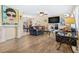 Bright living room with wood-look flooring, comfortable seating, and open layout at 10448 Hetrick W Cir, Largo, FL 33774