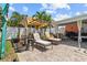 Backyard patio with lounge chairs, potted plants, and a shady pergola at 10448 Hetrick W Cir, Largo, FL 33774