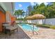 Backyard view features a pool, patio, and lounge seating at 10448 Hetrick W Cir, Largo, FL 33774