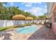 Inviting kidney-shaped pool surrounded by a brick patio and lush landscaping at 10448 Hetrick W Cir, Largo, FL 33774