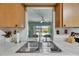 Stainless steel sink looking through window to the backyard and screened-in patio at 12933 90Th Ave, Seminole, FL 33776