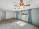Bright living room featuring a ceiling fan, natural light, and a view of the front yard at 14049 12Th St, Dade City, FL 33525
