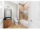 Bathroom with a tub, shower, and a wooden vanity cabinet at 1600 Magnolia Rd, Belleair, FL 33756
