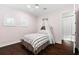 Charming bedroom featuring wood floors, arched windows, and a bed with a decorative canopy at 1600 Magnolia Rd, Belleair, FL 33756