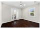 Bedroom featuring dark wood floors, window, sliding glass doors and ceiling fan at 1600 Magnolia Rd, Belleair, FL 33756