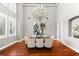 Formal dining room featuring hardwood floors, a dazzling chandelier, and expansive windows with shutters at 1600 Magnolia Rd, Belleair, FL 33756