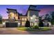 A luxurious home featuring a tower entry, arched windows, a balcony, multi-car garage, and an inviting driveway at 1600 Magnolia Rd, Belleair, FL 33756