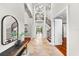 Grand foyer showcasing travertine floors, soaring ceilings, and a staircase with dark wood and iron railings at 1600 Magnolia Rd, Belleair, FL 33756