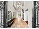 Elegant foyer with soaring ceilings, travertine flooring, and stunning staircase with iron railings at 1600 Magnolia Rd, Belleair, FL 33756