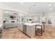 A modern kitchen with a large island with seating and stainless appliances overlooking the living room at 1600 Magnolia Rd, Belleair, FL 33756