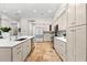A modern kitchen featuring stainless appliances, granite countertops, travertine tile floors, and lots of cabinets at 1600 Magnolia Rd, Belleair, FL 33756